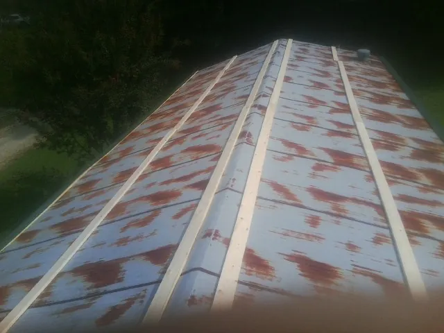 Rusted metal roof panels with new wood purlins before replacement — Storm Damage Roof Repair in Portal by Roofing Brothers