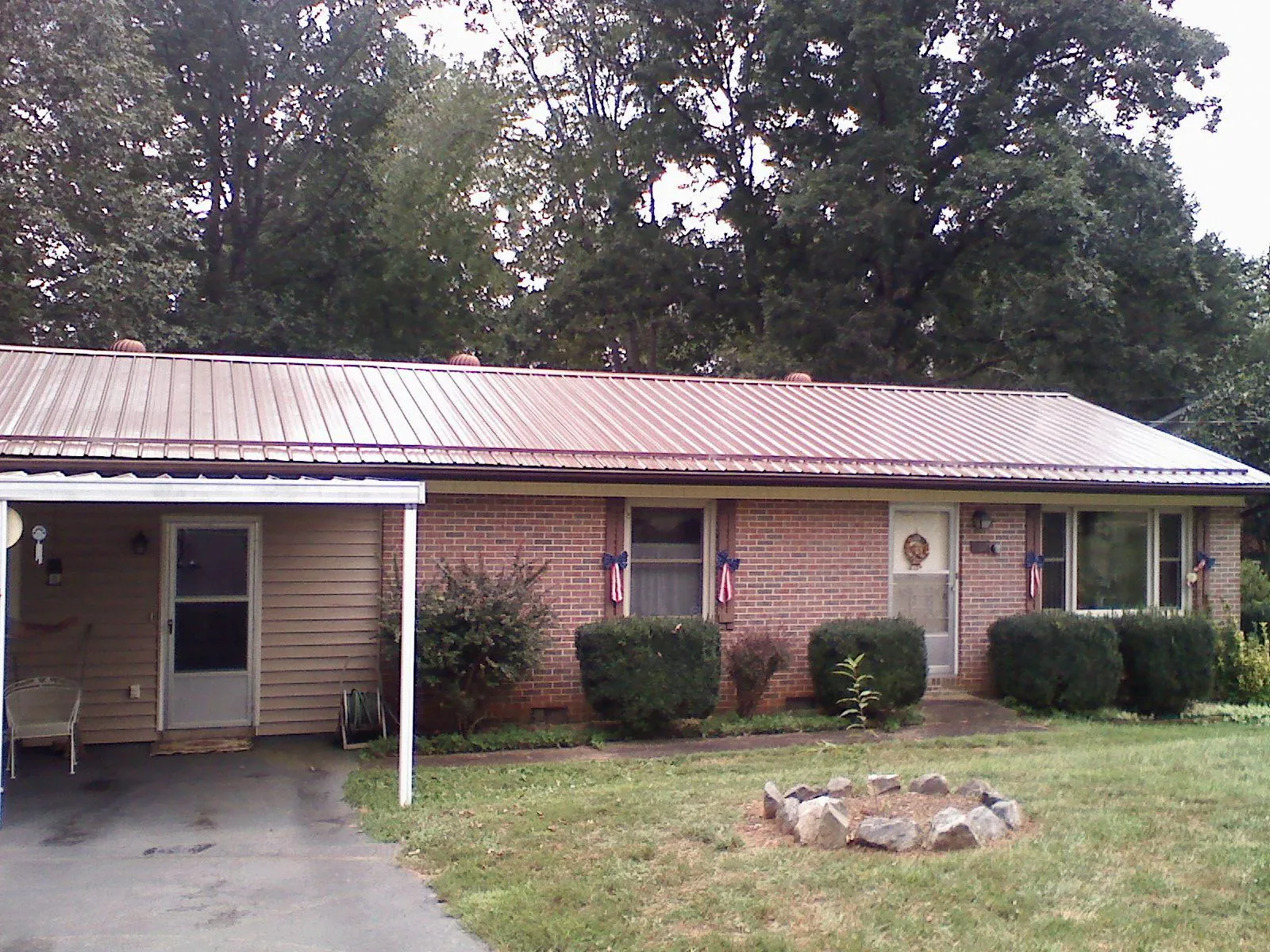 Bronze metal roof and carport on a brick ranch home — Roof Repair work by our crew in Portal