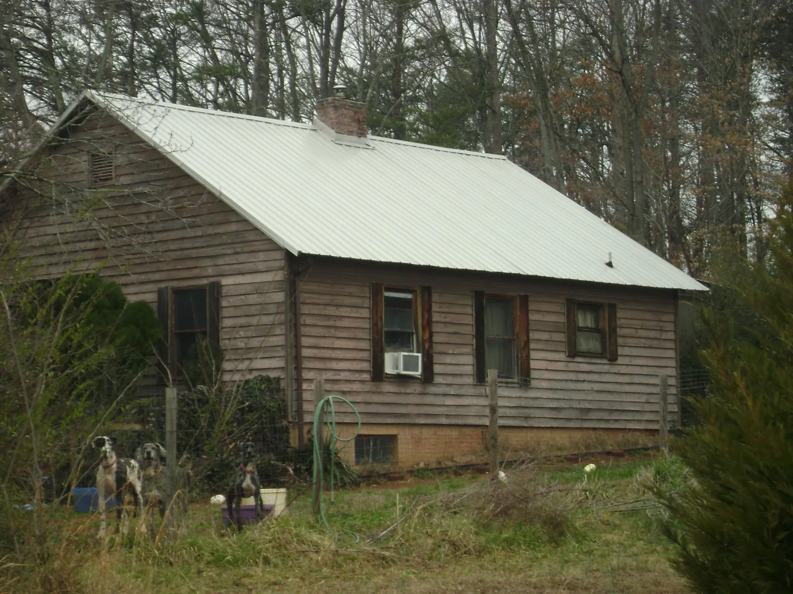 White metal roof on an old wood sided farmhouse, from a Metal Roof Installation job in Portal